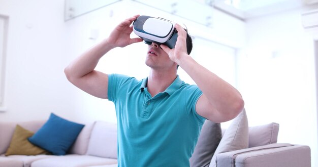 自宅でバーチャルリアリティのVRヘッドセットメガネを使用して経験を積んで幸せな男