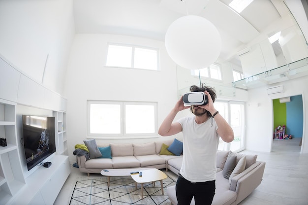 happy man getting experience using VR-headset glasses of virtual reality at home