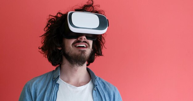 빨간색 배경에서 격리된 가상 현실의 VR 헤드셋 안경을 사용하여 경험을 얻는 행복한 사람