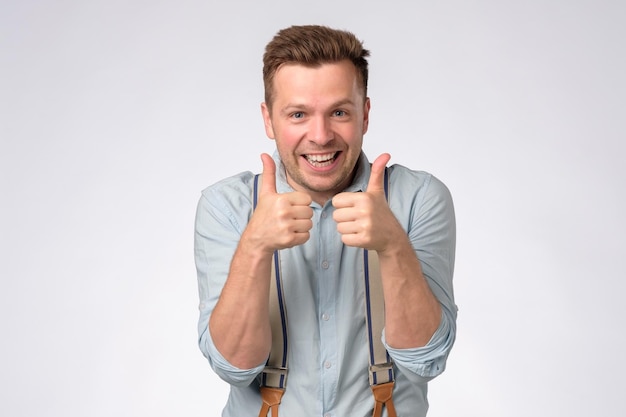 Happy man giving thumbs up sign approving choice