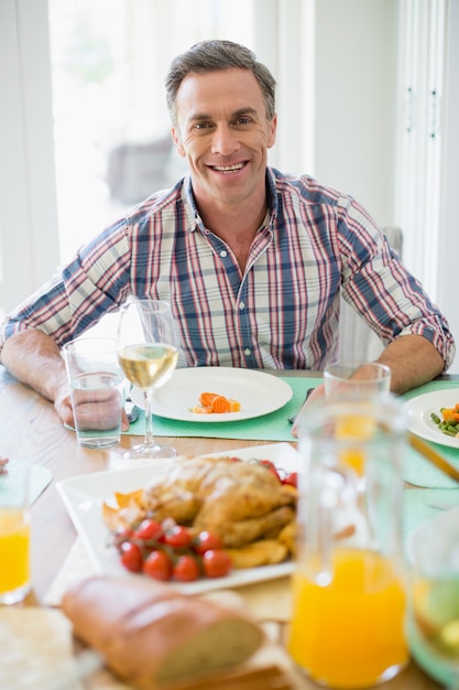 ダイニングテーブルで食事をして幸せな男