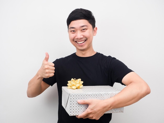 Happy man hodling gift box and thumb up