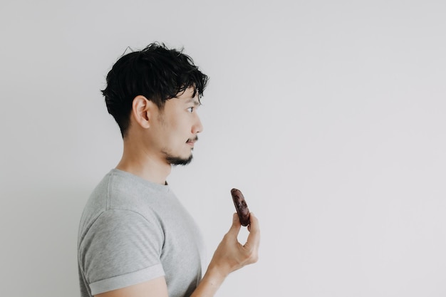 Счастливый человек, держащий шоколадное печенье, изолированные на белом фоне