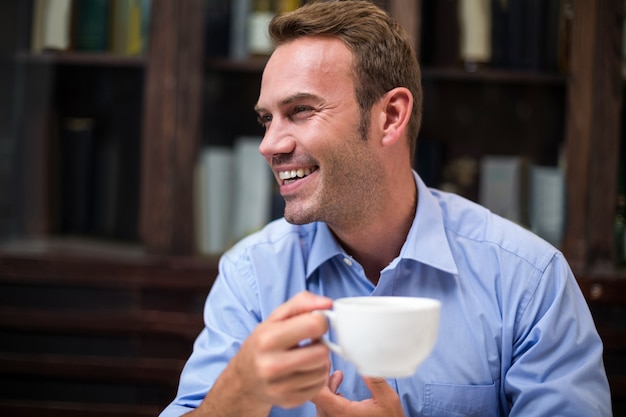 コーヒーカップを保持している幸せな男