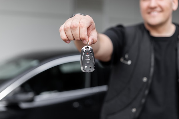 Photo happy man holding and giving car keys arneda auto sale of transport