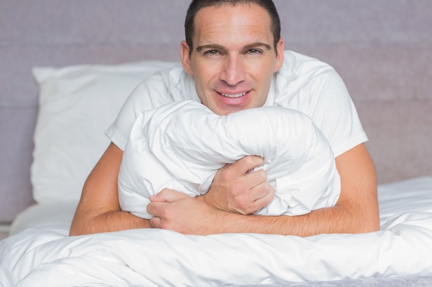 Счастливый человек обнимает свою подушку