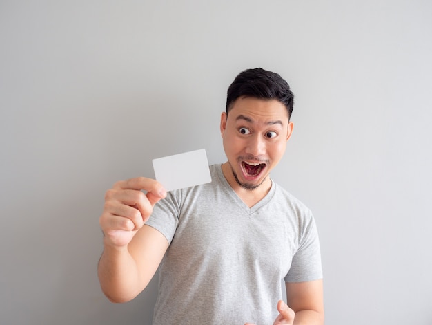 Happy man is showing a white credit card