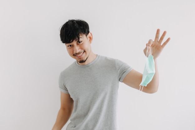 Happy man is taking off his mask after ending covid quarantine pandemic