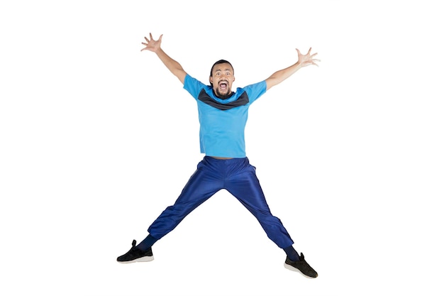 Happy man jump on studio while wears sportswear