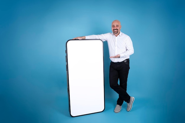 happy man leaning full body length of big cell phone Modern smartphone mock up idea