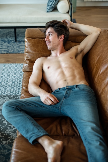 Happy man lying down on a couch