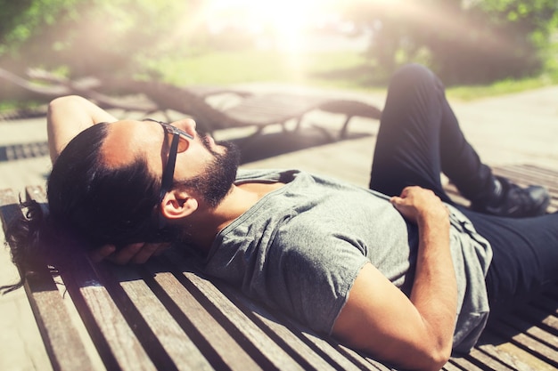 Photo happy man lying on street bench or sun bed