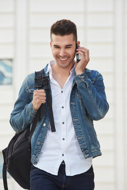 Happy man on mobile phone call standing and laughing