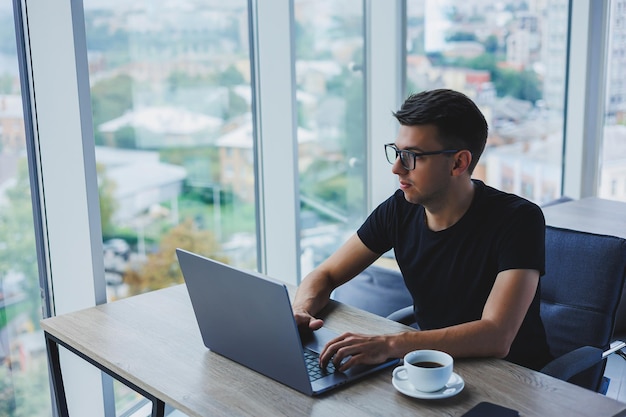 Happy man in optical glasses for vision correction looking for\
funny information in social networks using wireless connection on\
netbook technology concept