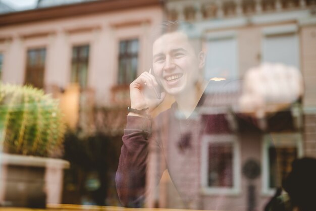 The happy man phone over the window