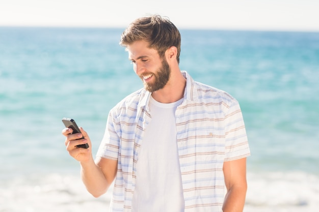 Happy man playing on his smartphone 