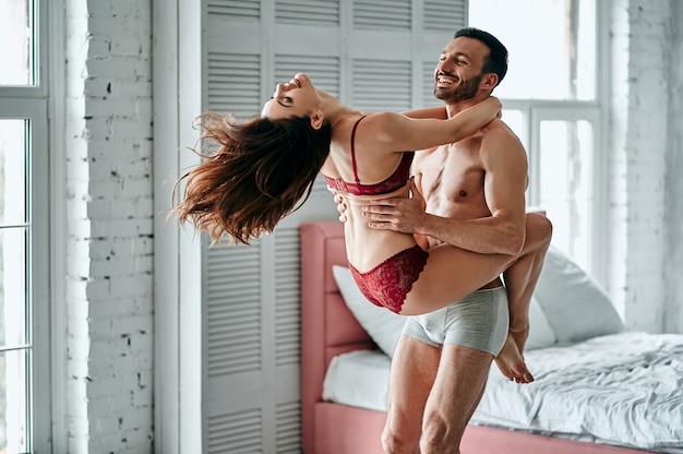 Premium Photo The happy man playing with a sexy woman in underwear in a bedroom