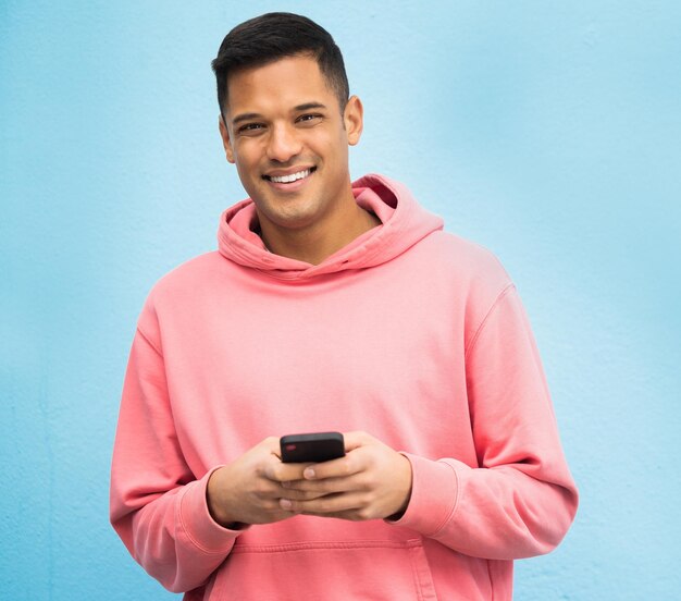 Happy man portrait or phone typing on isolated blue background on social media fashion app or city internet smile person or student model on mobile communication technology by brazil wall mockup