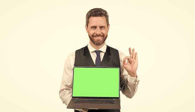 Uomo felice che presenta il prodotto del pc con lo schermo verde per lo spazio della copia che mostra la presentazione ok