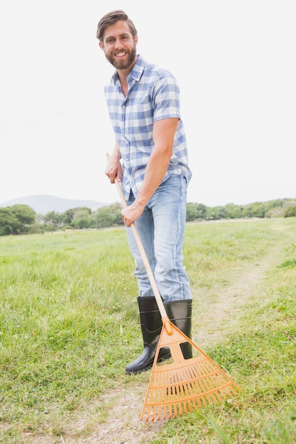 Happy man raking his farm