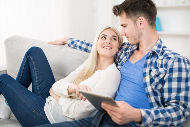 The happy man reading the book near the woman on a sofa