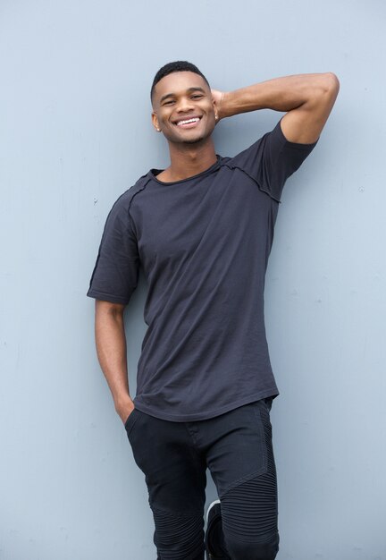 Happy man relaxing against gray background