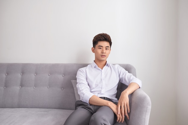 Happy man relaxing on couch at home in the living room