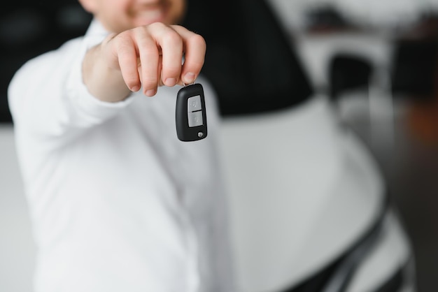 Happy man showing the key of his new car