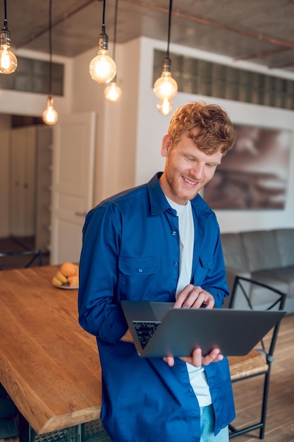 A happy man sitting at the table in the home office and working