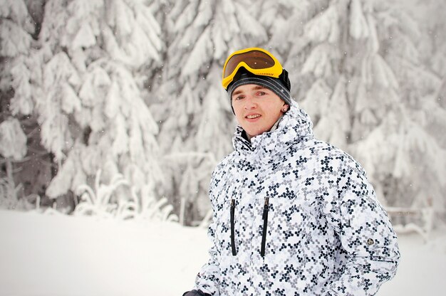 Happy man in ski eyeglasses stand in Carpathian mountains