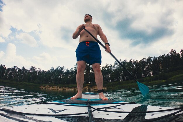 Happy man on supboard paddling