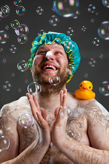 Photo happy man taking bath and applauding for soap bubbles