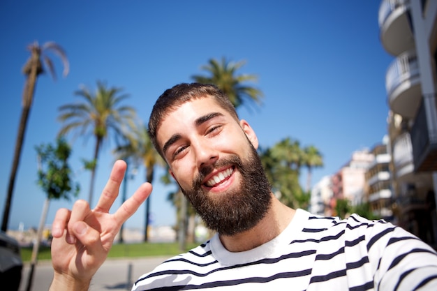 Happy man taking selfie by palm trees