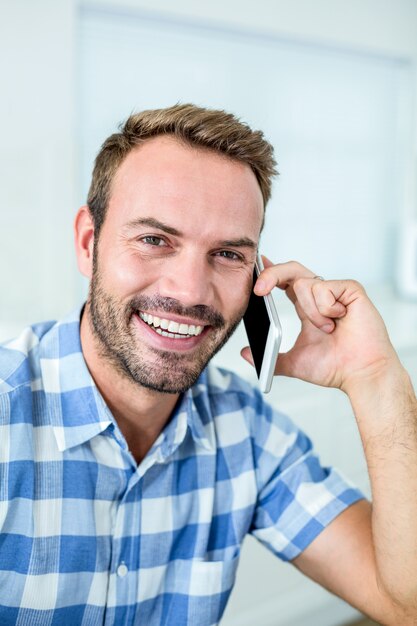 自宅で携帯電話で話している幸せな男