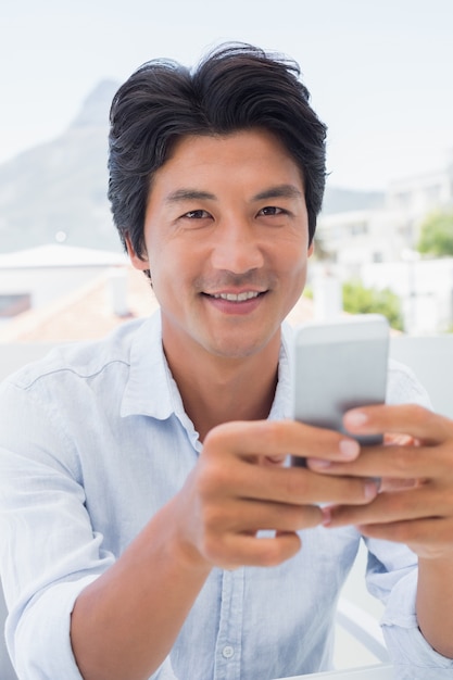 Photo happy man texting on phone