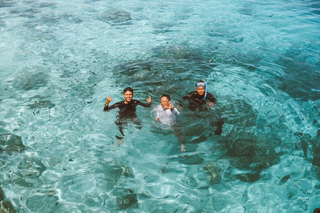 Il turista felice dell'uomo scatta una foto insieme sull'acqua di mare trasparente