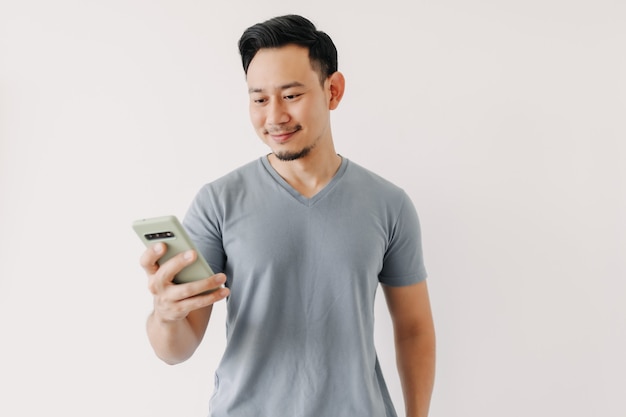 L'uomo felice usa lo smartphone isolato su sfondo bianco
