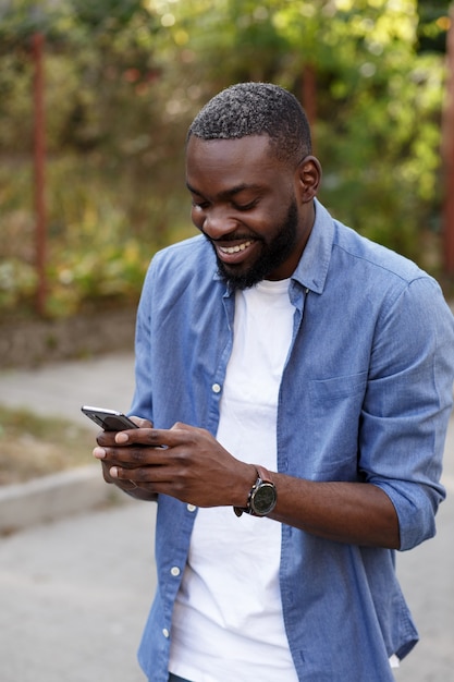 Uomo felice che utilizza app per telefoni cellulari, messaggi di testo, navigazione in internet, guardando smartphone