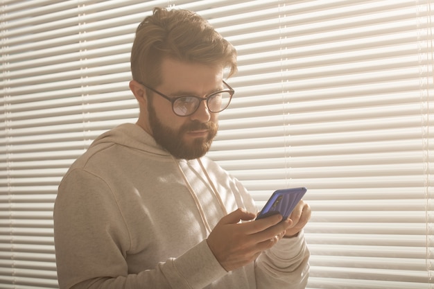 Happy man using mobile phone at home or at office