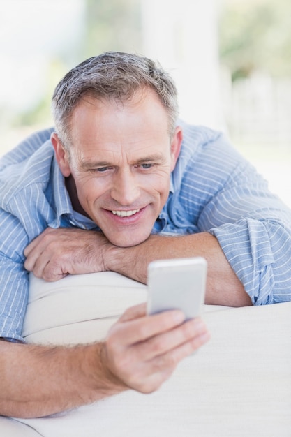 Happy man using smartphone in the living room