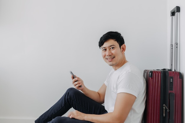 Фото Счастливый человек использует приложение для путешествий на телефоне в ожидании транспорта