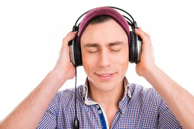 Happy man in violet cap listening music with closed eyes