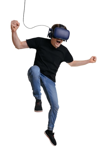 Happy man in VR glasses is screaming and making winner gesture isolated on white background