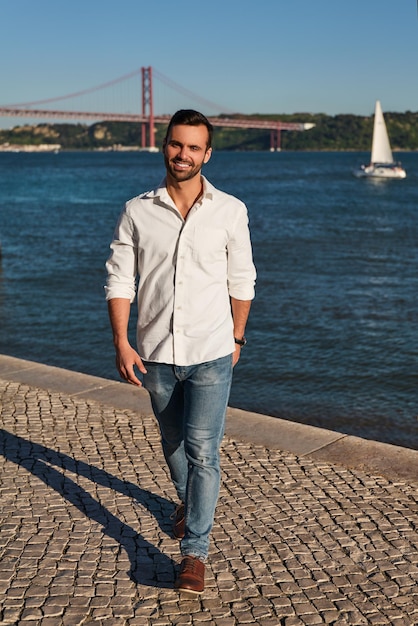 Happy man walking on embankment