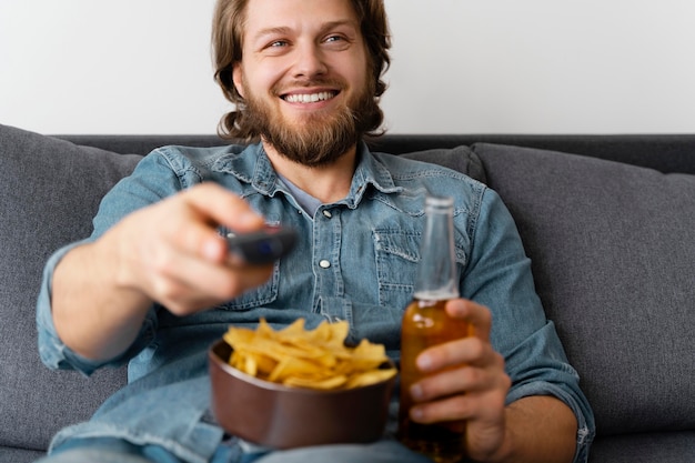 Photo happy man watching tv at home