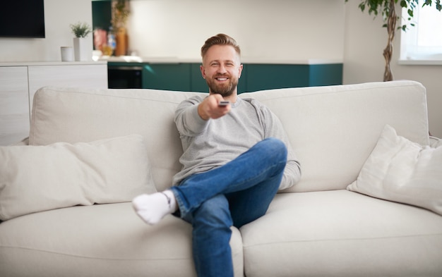 Happy man watching tv on sofa