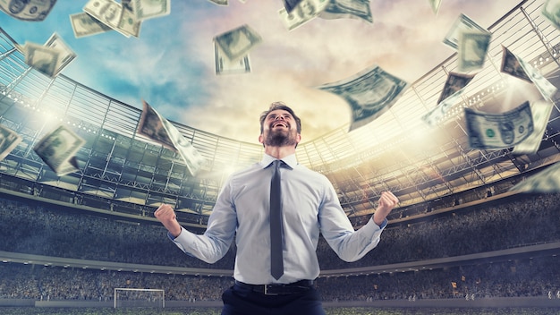 Happy man for winning a sport bet rain of money inside a soccer stadium