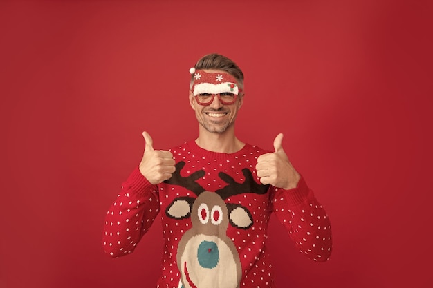 Happy man in winter sweater and party santa claus glasses xmas guy