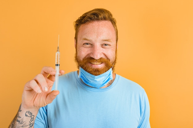 Happy man with beard tattoo and mask for covid is ready for the virus vaccine