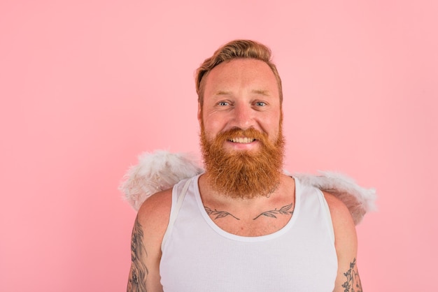 Happy man with beard and tattoos acts like an angel